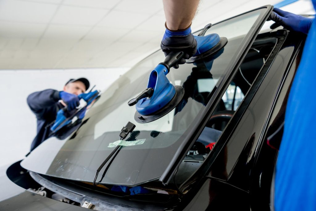 Workers performing maintenance for car glass